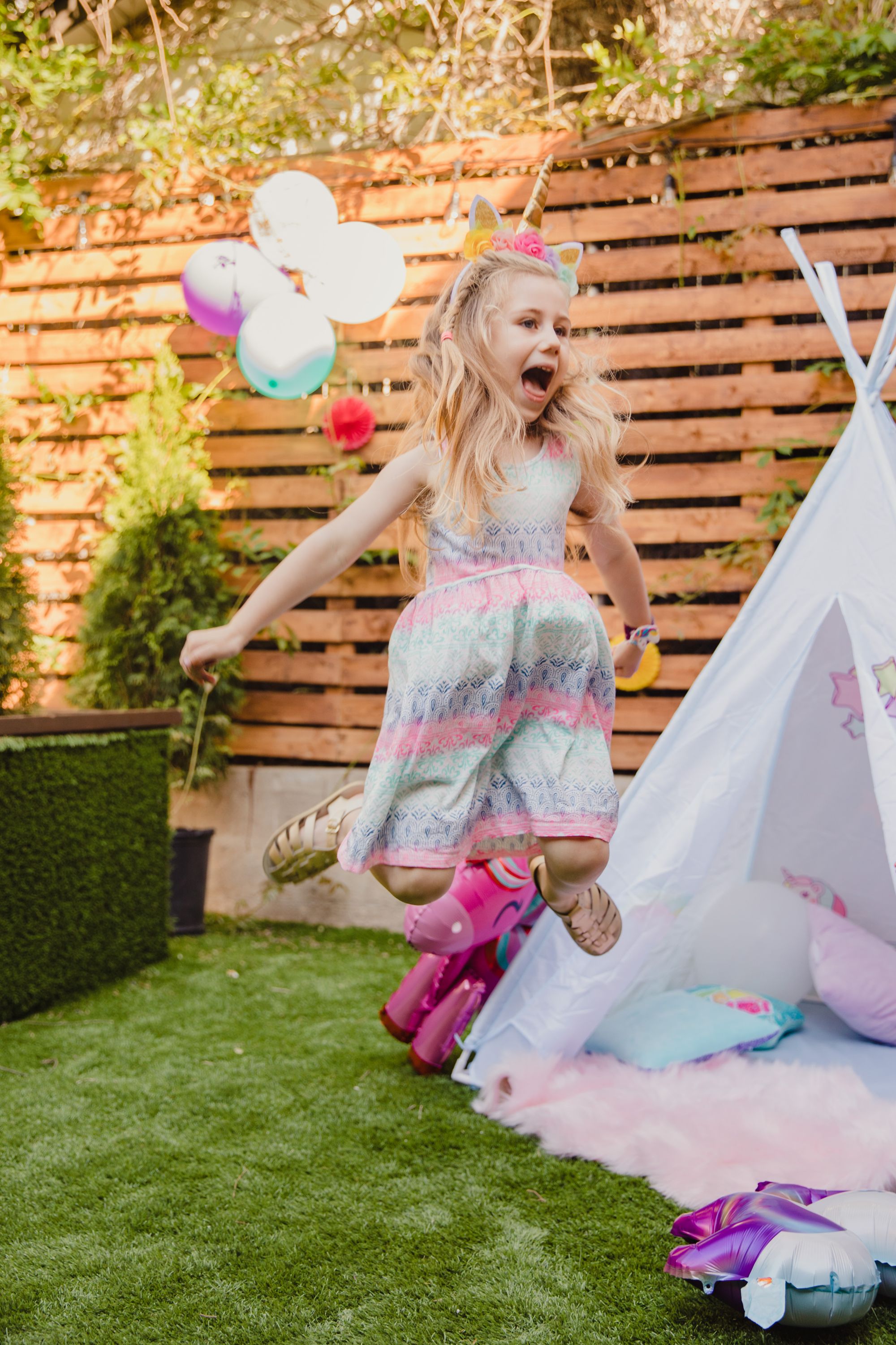 A child leaping with excitement at a backyard party
